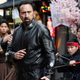 Nicolas Cage strikes a martial arts pose in Prisoners of the Ghostland while several bystanders watch him closely.